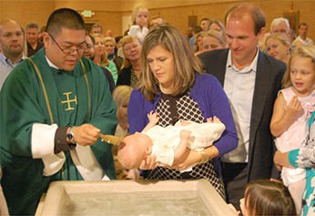 Fr Brian Ching, CSC performing a Baptism