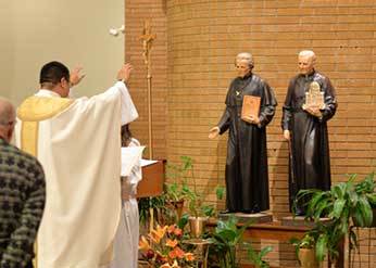 Fr Brian Ching, CSC blesses the new statues