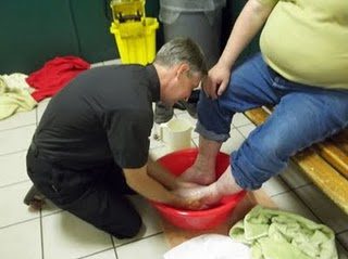 Fr Eric washing feet at Andre House