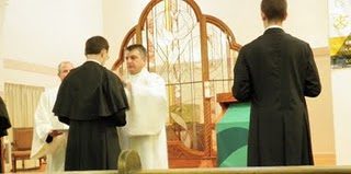 Fr Kevin Russeau, CSC gives the Newly Professed the cape for their habits