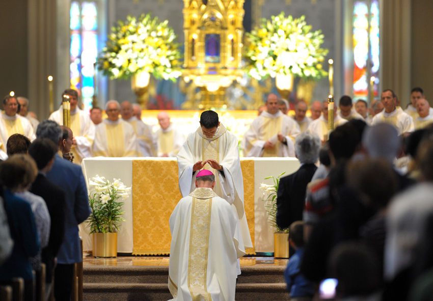 Fr Matt Kuczora, CSC giving the Bishop the first blessing