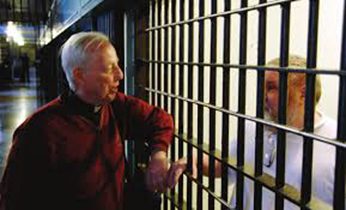 Fr Tom McNally, CSC visiting with an inmate