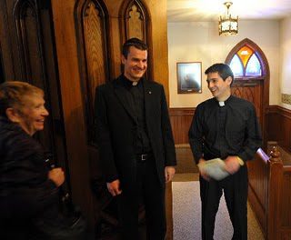 Fr Aaron Michka, CSC and Fr Vince Kuna, CSC talking with a parishioner