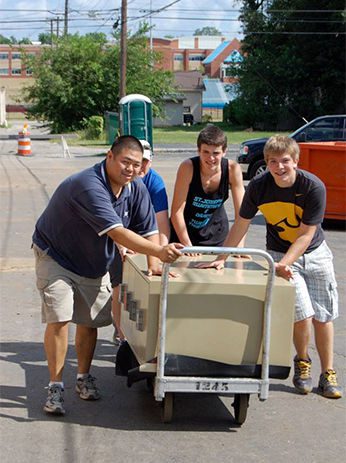 Fr Brian Ching, CSC with the help of parishioners move the parish office