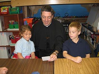 Fr John passing out St Andre prayer cards