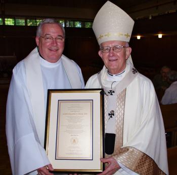 Father David Tyson presents Archbishop John Vlazny with the Spirit of Holy Cross Award