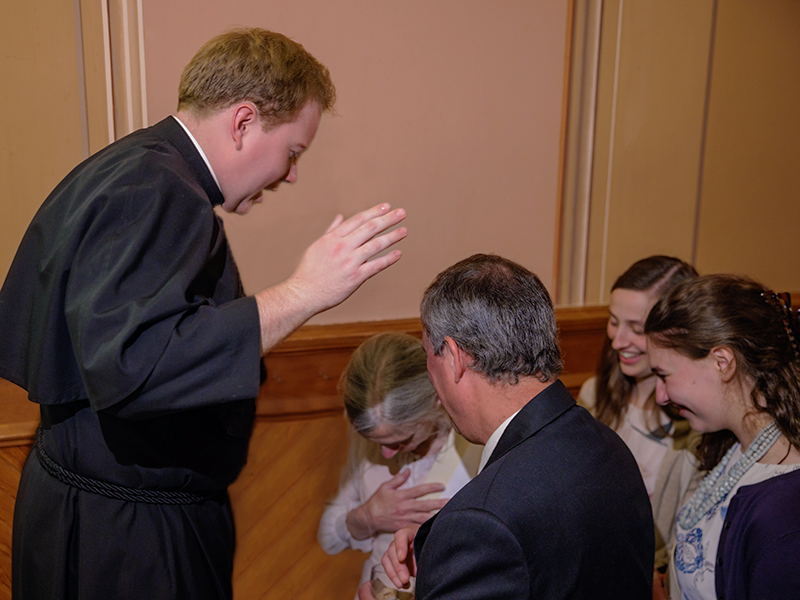Fr. Andrew Fritz CSC prays over family and friends