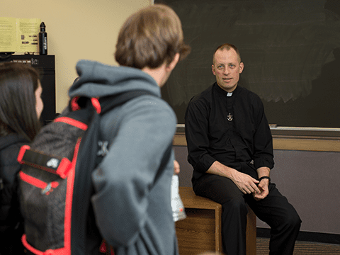 Fr. Dan Parrish talks with a student