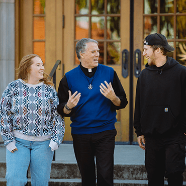 Fr Pat Hannon CSC walks  and talks with lay collaborators