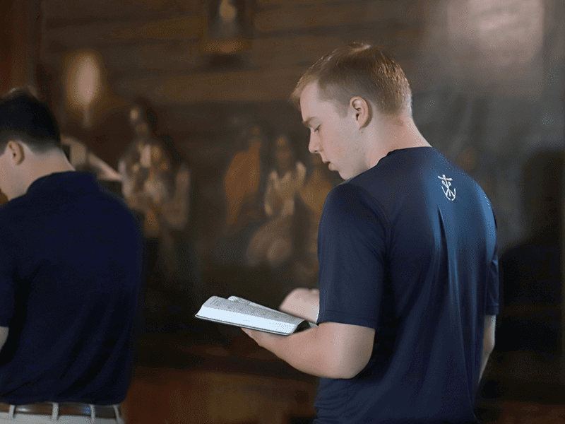 seminarian praying at Log Chapel Mass at Notre Dame