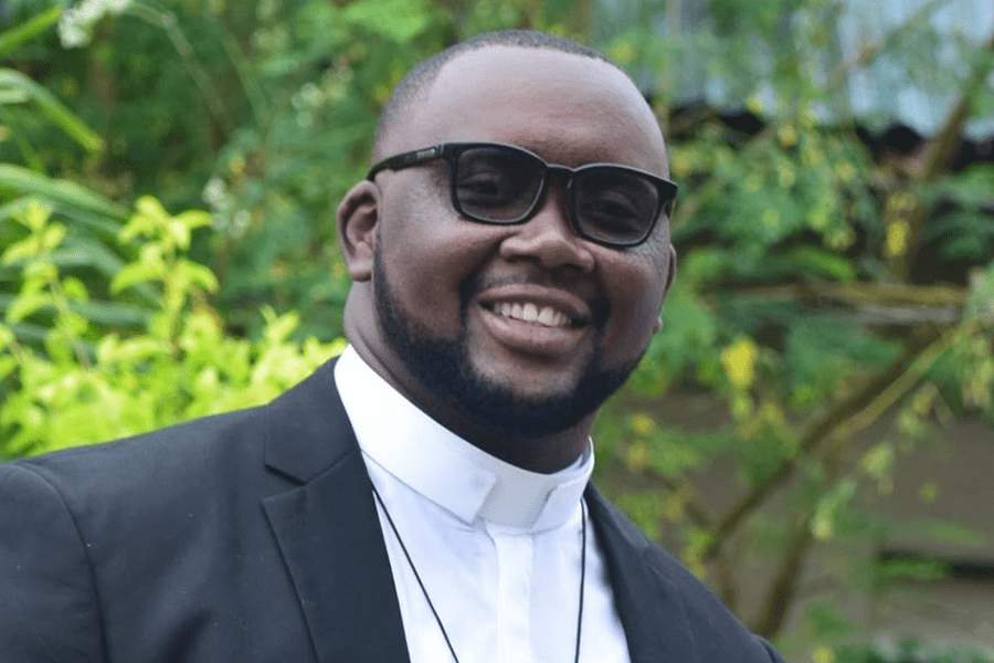 Priest with sunglasses smiling at camera