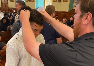 A coach at King's College bestows a medal on a football player