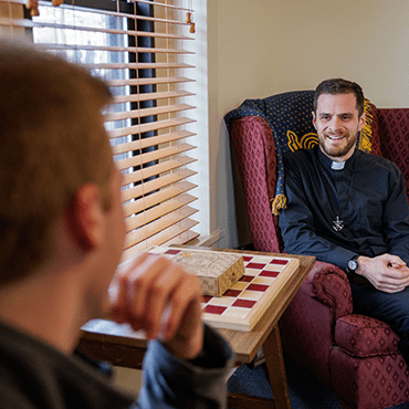 Holy Cross priest talking with a student