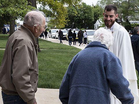 CSC priest gives communion to a young parishioner