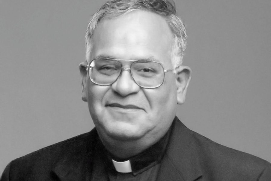 A black and white professional headshot of Rev. Genaro P. Aguilar.