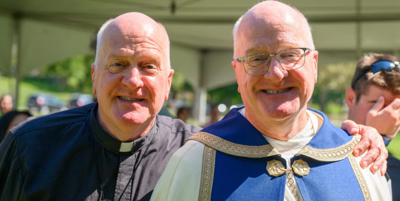 Rev. James Lies stands with brother Rev. William Lies at the dedication of the Rosary Walk.