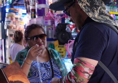 A man in formation shares a rosary with an older woman at a market during the Chile-Peru Missionary Outreach
