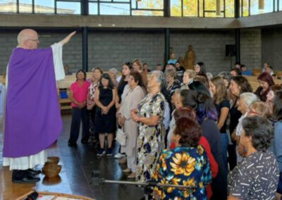 Fr. Bill Lies bestowing a blessing over a group of volunteers at a March 2026 visit to Chile-Peru,