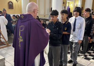 Fr. Bill Lies, C.S.C., distributing communion to males students at Mass during a March 2026 Chile-Peru.