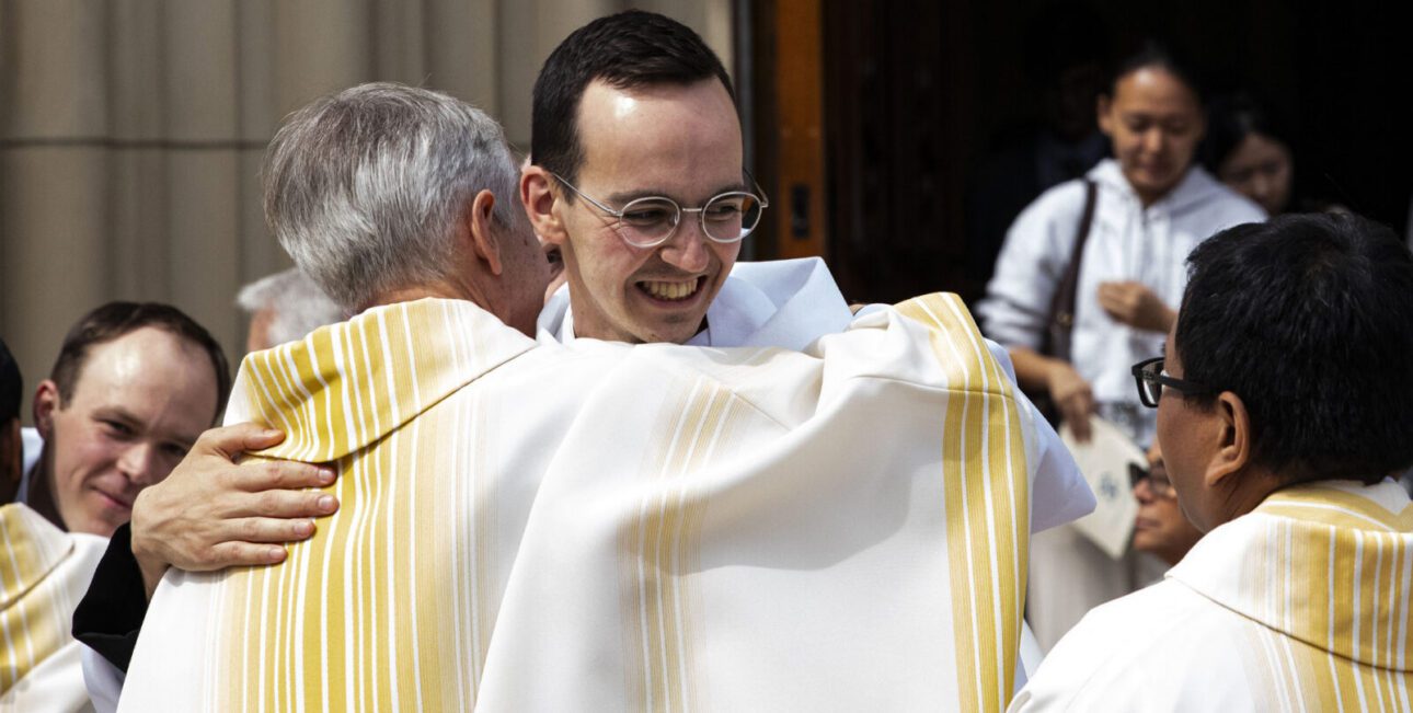 Fr Michael Ryan kneels before Bishop Rhoades and receives a blessing before delivering the Gospel.