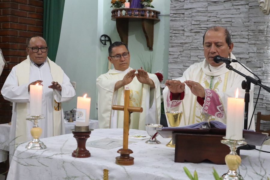 Three priests praying over the Eucharist at the alter at Lord of Hope Parish