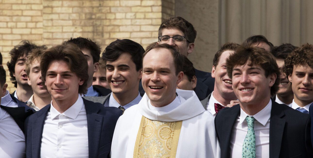Brother Bobby McFadden, C.S.C., Fr. Ricky Bevington, C.S.C., Fr. David Murray, C.S.C., Fr. Aaron Morris, C.S.C., and Fr. Noah Junge, C.S.C., walk along the campus of the University of Notre Dame.