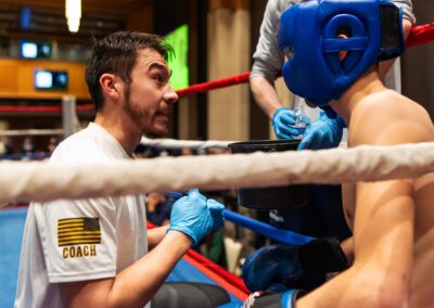 University of Notre Dame male boxer is coached by a male in the boxing ring.