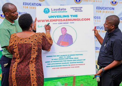 Educators sign a poster about a new program at the Holy Cross Lake View S.S.S. Laudato Si' festival