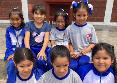 Young female students at St. Brendan Kitete school post outside the school building