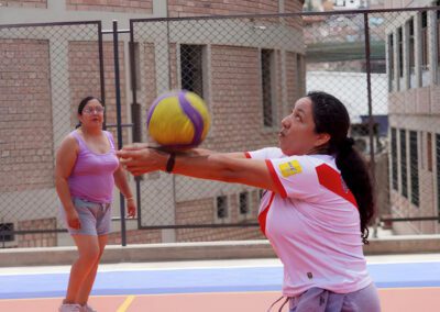Two young women playing volleyball at the new Brother Juan Benesh, C.S.C., Mini Coliseum in Lima, Peru.