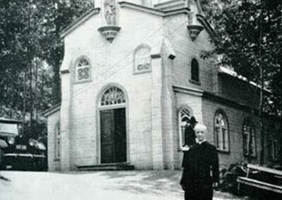 Br. André Bessette, C.S.C. standing in front of St. Joseph Chapel